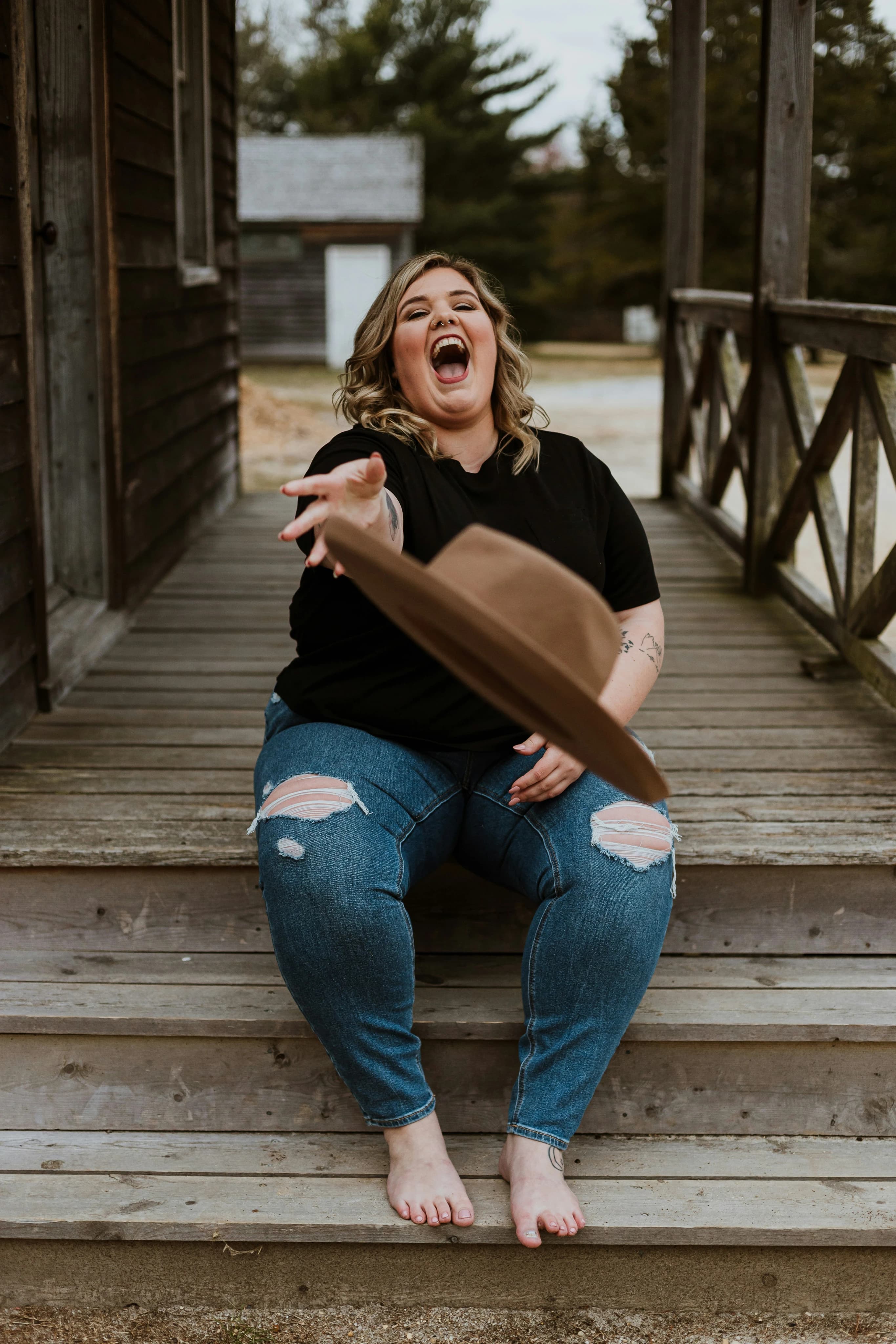 A smiling woman joyfully tossing her hat